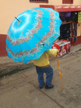 Colombia - "Onder moeders paraplu". Klein mannetje onder een enorm grote paraplu.